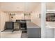 Functional laundry room with washer, dryer, gray cabinets, countertop, and white tile flooring at 1795 N Monaco St Pkwy, Denver, CO 80224