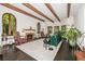 Cozy living room with exposed beams, a decorative fireplace, and large arched windows at 1795 N Monaco St Pkwy, Denver, CO 80224