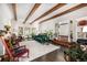 Bright living room featuring wood beams, a green sofa, and a decorative fireplace at 1795 N Monaco St Pkwy, Denver, CO 80224