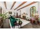 Open living room features hardwood floors, exposed beams, and plenty of natural light at 1795 N Monaco St Pkwy, Denver, CO 80224