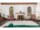 Living room showcasing a decorative fireplace, arched windows, and hardwood flooring at 1795 N Monaco St Pkwy, Denver, CO 80224