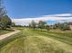 Scenic golf course featuring rolling greens, mature trees, and a winding cart path at 13598 E Asbury Dr, Aurora, CO 80014
