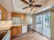 Efficient kitchen area with natural wood cabinetry, appliances, and a view to the living room at 13598 E Asbury Dr, Aurora, CO 80014