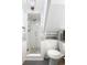 A compact bathroom featuring a tiled shower with pebble floor, toilet, and built-in shelves at 424 S Leyden St, Denver, CO 80224