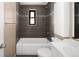 Bathroom with gray tiled walls, shower and tub, vanity with undermount sink and toilet at 424 S Leyden St, Denver, CO 80224