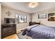 Bedroom with light hardwood flooring, large windows, dresser and a television set at 424 S Leyden St, Denver, CO 80224