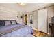Bedroom with wood accent wall, light hardwood floors, barn door to en suite bath at 424 S Leyden St, Denver, CO 80224