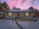 Brick ranch home with snowy yard, illuminated at dusk at 424 S Leyden St, Denver, CO 80224