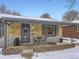 Brick ranch home with snowy front yard and welcoming porch at 424 S Leyden St, Denver, CO 80224