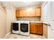 Convenient laundry room equipped with cabinets, sink, and modern appliances at 5550 Fox Meadow Ave, Highlands Ranch, CO 80130
