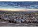 An aerial view showcases the community with mountain views and cloudy skies at sunset at 2957 Eagle Wing Way, Castle Rock, CO 80109