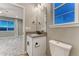 Bathroom with a gray countertop, white cabinets, and a view of a bedroom with a large window at 2957 Eagle Wing Way, Castle Rock, CO 80109