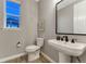 Elegant powder room features a stylish pedestal sink, modern fixtures, and a sleek black-framed mirror at 2957 Eagle Wing Way, Castle Rock, CO 80109