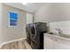 Well-equipped laundry room featuring modern washer and dryer, practical sink, and stylish tile accents at 2957 Eagle Wing Way, Castle Rock, CO 80109