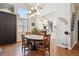 Elegant dining room with a round wood table, hardwood floors, and a modern chandelier at 1913 Five Iron Dr, Castle Rock, CO 80104