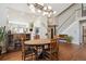 Bright dining room featuring hardwood floors, a rustic wood table, and a modern light fixture at 1913 Five Iron Dr, Castle Rock, CO 80104
