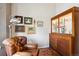 Cozy living area with a leather armchair, display cabinet, and curated artwork for a refined living experience at 1913 Five Iron Dr, Castle Rock, CO 80104