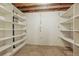 Unfinished basement area with exposed ceiling, concrete floor, and basic shelving units for storage at 2838 S Heather Gardens Way # A, Aurora, CO 80014
