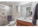 Cozy bathroom featuring a glass-enclosed shower, vanity with sink, toilet, and nautical decorations at 2838 S Heather Gardens Way # A, Aurora, CO 80014