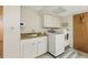 Functional laundry room area with washer, dryer, utility sink, and storage cabinets at 2838 S Heather Gardens Way # A, Aurora, CO 80014