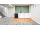 Basement bar area with white cabinetry, green tile backsplash and beverage cooler at 1248 Ilium Dr, Lafayette, CO 80026