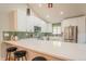 Bright kitchen with white cabinets, stainless steel appliances, quartz counters, and bar seating at 1248 Ilium Dr, Lafayette, CO 80026