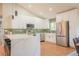 Gourmet kitchen with white cabinetry, stainless steel appliances, and a quartz countertop breakfast bar at 1248 Ilium Dr, Lafayette, CO 80026