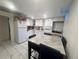 Bright kitchen with white cabinets, appliances, and a dining table at 5411 Chandler Way, Denver, CO 80239
