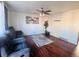 Inviting living room featuring hardwood floors, a ceiling fan, and a comfortable, oversized couch at 5411 Chandler Way, Denver, CO 80239