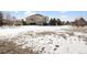 Large backyard with patchy snow and partial house view at 7285 Sagebrush Dr, Parker, CO 80138