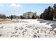 Large backyard with patchy snow, playground, and house view at 7285 Sagebrush Dr, Parker, CO 80138