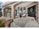 Stone porch with seating area and a black front door at 7285 Sagebrush Dr, Parker, CO 80138