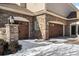 Three car garage with stone exterior and wood doors at 7285 Sagebrush Dr, Parker, CO 80138