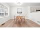 Dining room features light wood floors, a modern light fixture, and a large window at 1129 W 112Th Ave # C, Denver, CO 80234