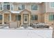 Charming townhome featuring a brick facade and covered entryway during the winter season at 1129 W 112Th Ave # C, Denver, CO 80234