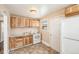 Bright kitchen featuring wood cabinets, white appliances, and tiled floors at 1200 Newark St, Aurora, CO 80010