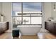 A luxurious bathroom showcases a modern soaking tub by a large window, offering a serene bathing experience at 2800 E 2Nd Ave # 202, Denver, CO 80206