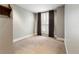 A simple bedroom provides a clean canvas with neutral walls, plush carpeting, and a window with privacy shades at 2800 E 2Nd Ave # 202, Denver, CO 80206