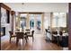 Open-concept dining room with glass table, modern chandelier, and fireplace at 2800 E 2Nd Ave # 202, Denver, CO 80206