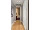 This naturally lit hallway features hardwood flooring, decorative painting, and an open view to the adjacent powder room at 2800 E 2Nd Ave # 202, Denver, CO 80206