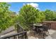 Great outdoor balcony space featuring a dining table and mature tree views at 1000 Elmhurst Dr # B, Highlands Ranch, CO 80129