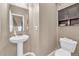 Cozy half bathroom with a pedestal sink, toilet, and a decorative mirror at 1000 Elmhurst Dr # B, Highlands Ranch, CO 80129