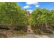 Exterior of home with nicely landscaped entrance, stairs and large shade trees at 1000 Elmhurst Dr # B, Highlands Ranch, CO 80129