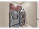Modern laundry room with side-by-side washer and dryer and built-in cabinetry at 1000 Elmhurst Dr # B, Highlands Ranch, CO 80129