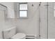 Bright bathroom featuring a toilet, towel rack, and glass shower with white marble tile at 7076 S Spruce W Dr, Centennial, CO 80112