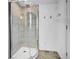 Modern bathroom featuring glass shower enclosure and neutral-toned tiled walls at 7076 S Spruce W Dr, Centennial, CO 80112