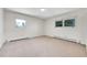 Spacious bedroom with carpeted floors, two windows, and baseboard heaters at 7076 S Spruce W Dr, Centennial, CO 80112