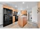 Well-lit kitchen featuring light wood cabinets, black appliances, and stone tile flooring at 7076 S Spruce W Dr, Centennial, CO 80112