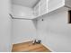 Laundry room featuring wood-look floors, white walls, shelving, and metal ductwork at 7076 S Spruce W Dr, Centennial, CO 80112