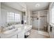 Bright bathroom with vanity, large mirror, tiled shower with glass door, and abundant lighting at 13228 E Asbury Dr, Aurora, CO 80014